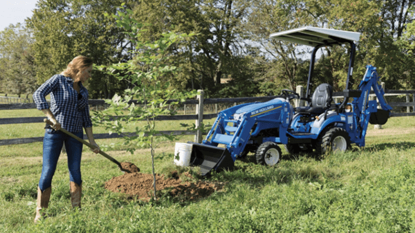 Woman using tractor to help plant a tree