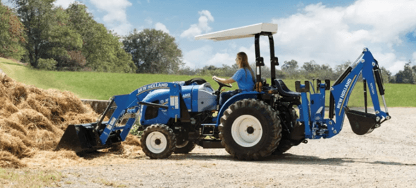 Tractor moving hay from pile