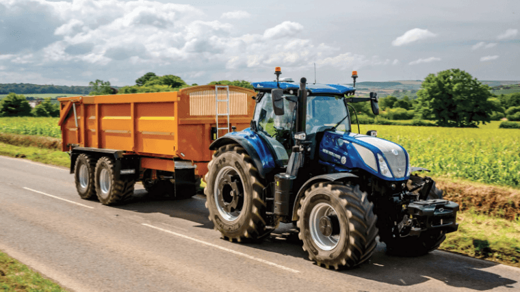 Tractor hauling a large trailer on the road