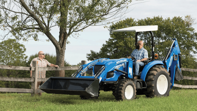 Two men talking over a tractor