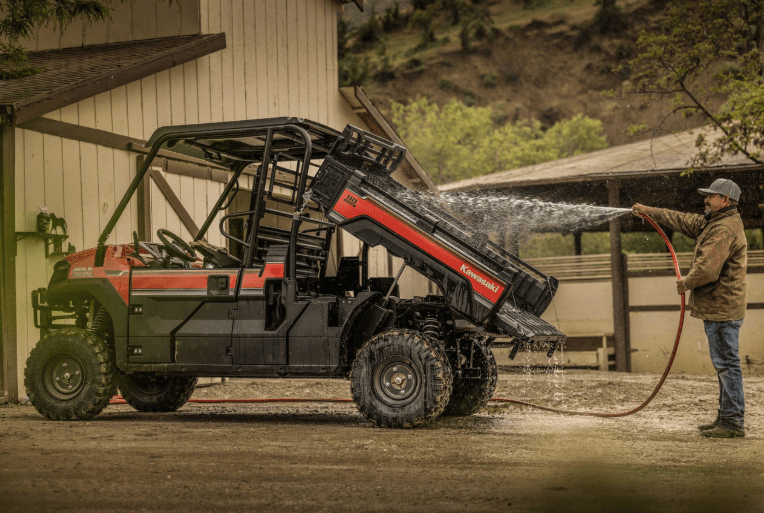 Man cleaning cargo bed of utility vehicle