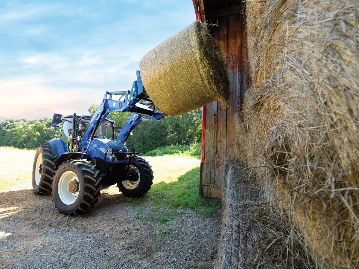New Holland Tractor lifting a hay bale