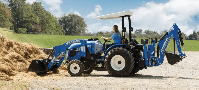 Woman using tractor to scoop material