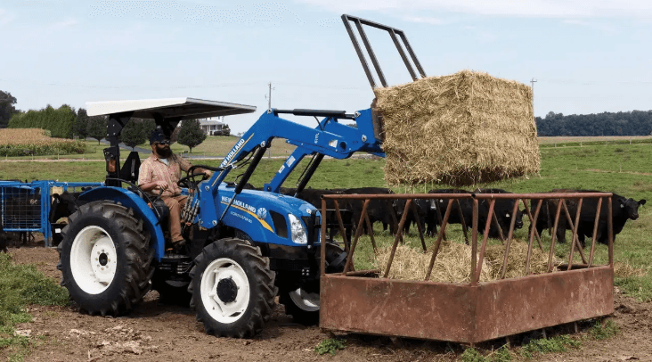 Man using Compact Tractor to load hay